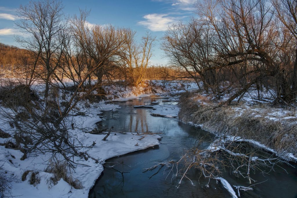 Photo by Tom Fisk: https://www.pexels.com/photo/a-river-between-leafless-trees-on-a-snow-covered-ground-11636066/